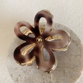 Close-up of marble resin flower hair claw clip with golden metal petal edges and center - 6.7cm / Tortoise