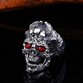 Detail eines gotischen Silber-Totenkopfrings mit auffälligen roten Edelsteinaugen vor Schwarz - Einstellbar Offen / Rote Augen