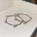 Macro shot of silver hoop earrings featuring intricate small butterfly charms on jewelry box - Silver-Butterfly