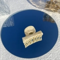 Detail of beige marble pattern hair claw clip on mirror surface with light reflection - Cappuccino