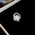 Macro shot of silver ring featuring a white 3D flower surrounded by small pearls - Ring