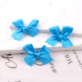 Three bright blue satin ribbon hair bows on a textured white background - Sapphire Blue