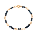 Detailed close-up of golden chain bracelet with dark blue faceted beads and spring clasp - Bracelet