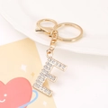 Detailed view of metal letter E keychain with pavé rhinestones and lobster clasp closure - Letter E