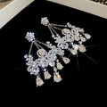 Close-up of sparkling flower tassel earrings with crystals on black velvet display - Silver (Silver Pin) / Silver