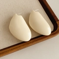 Dettaglio ravvicinato di orecchini geometrici in resina crema su vassoio in legno - Perno in argento-Bianco