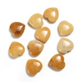 Detailed macro view of ten heart-shaped yellow natural gemstone crystals on white backdrop - Topaz