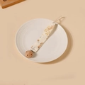Détail de l'attache-tétine en coton fleuri avec clip en bois de hêtre sur assiette - Style Floral Crème (16)