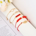 Dettaglio del set di 5 bracciali dorati con perline rosse, cuore e infinito su supporto bianco - Set da 5 pezzi / MS8080 Rosso