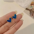 Macro shot of blue heart stud earrings with gold trim held on fingertips for scale - Deep Blue Heart Gold Edge Minimalist Stud (A42)