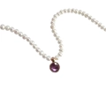 Dettaglio di una collana di perle bianche con ciondolo in pietra rotonda viola su bianco - Febbraio Ametista
