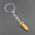 Macro detail of hexagonal yellow agate stone pendant with silver metal keychain - Topaz