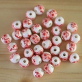 Macro shot of ceramic round beads with red plum blossom patterns on light wood background - No.29-Red Plum Blossom