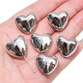 Polished silver heart-shaped acrylic beads for DIY jewelry making shown on hand - Polished Heart Style / 20x18mm (4 Pieces/Pack) / Silver