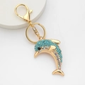 Detail of a golden dolphin keychain with blue and iridescent crystals on white background - Dolphin 1 (Blue)