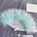 Détails d'éventail en plumes vert menthe avec manche blanc sculpté et pompon élégant - Éventail en Plumes Vertes et Dentelle