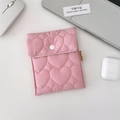 Rosa gesteppte Damenbindentasche mit Herzmuster, Druckknopf und Etikett auf Schreibtisch - Herz Rosa