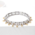 Elegant stainless steel link bracelet with gold charms on white display stand - Pale Yellow