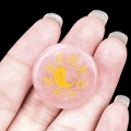 Round pink rose quartz stone with golden Yin Yang Bagua symbol held in hand - Rose Quartz