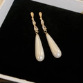Detailed view of long gold snowflake earrings with drop pearls and zircon on black velvet - Real Gold Plated Silver Needle Style / Gold