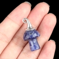 Silver metal Christmas hat and blue stone mushroom pendant held by hand on black background - Gun Black Cap / Sodalite