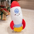 Peluche de cohete de dibujos animados en rojo, blanco y azul en una habitación festiva - Cohete pequeño