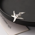 Silver starfish open ring with hammer texture finish on a minimalist display - Silver Starfish Hammered Ring (4516)