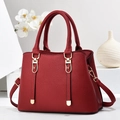 Detail der roten Handtasche aus Leder mit Litschimuster und eleganten Goldbeschlägen - 28cmx12cmx20cm / Weinrot