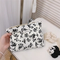Gros plan d'une trousse à maquillage vintage en coton avec l'étiquette Simple Wish - Blanc Avec Fleurs Noires