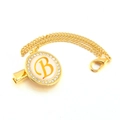 Close-up of golden pacifier clip with rhinestone encrusted letter B and metal chain - Letter B