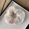 Close-up of a tweed scrunchie with lace trim and pink bow in a white display box - Bowknot Style / White