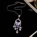 Macro shot of silver flower pendant necklace with tassels and shimmering crystal accents - Necklace-Silver-White
