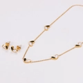 Dettaglio del set di gioielli a cuore dorato con inserti in madreperla bianca e nera - Oro