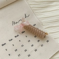 Detail of banana hair clip featuring spiral tube design and elegant ribbon bow - Bow Telephone Line Ring / Floral Pink