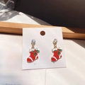 Detail of a Christmas stocking earring with red enamel, green leaf, and a shiny crystal - Christmas Sock