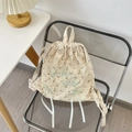 Detail eines geblümten Canvas-Rucksacks mit grünen Schleifen und Stickereien - Beige mit Twill-Blumenmuster