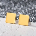 Macro shot of minimalist square gold stud earrings on textured white stone background - Square / Gold