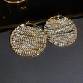 Macro-opname van grote goudkleurige oorringen met glanzende strass-steentjes en ster-effect - Goud / Goud