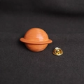 Cute cartoon orange planet enamel pin with gold butterfly clutch on dark fabric - Saturn Design