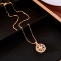 Dettaglio macro del ciondolo a sole placcato oro con zircone su velluto nero elegante - Collana - Oro (Placcato Oro)