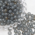 Detailed view of 8mm gray glass beads with gold crackle patterns in a glass bowl - Grey Brushed