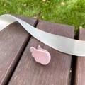 Barrette à cheveux rose en forme d'aile avec strass brillants sur un banc en bois foncé - Rose