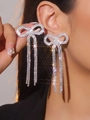 Detailed view of long bowknot tassel earrings with rhinestones worn by a model - Silver Bowknot Tassel