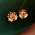 Primo piano di orecchini vintage dorati con zirconi rossi e trasparenti su velluto verde - Orecchini a Lobo Oro e Rosso (Perno per orecchini in argento)