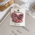 Detailed flat lay of handmade pink fabric hair clips with floral embroidery and bow - Flower Bow