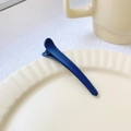 Deep blue matte duckbill hair clip displayed on a minimalist beige ceramic plate - Cyan