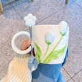 Detailed view of white ceramic mug featuring blue tulip relief and matching floral spoon - Cup + Spoon / Blue