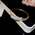 Détail d'un bracelet doré double couche avec quatre perles et zircons scintillants - Or-Quatre Perles Double Cercle (30#HB3099)