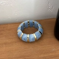Détail du bracelet élastique en résine marbrée bleu ciel et segments dorés - Bleu