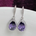Close-up of pear-cut purple zircon drop earrings with micro-pave halo setting - Purple